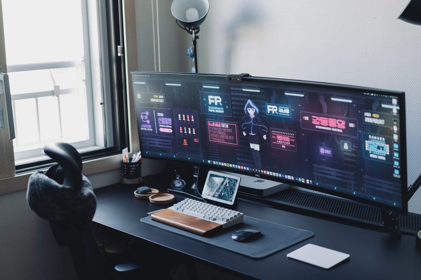 Un monitor ultrawide mostra una grafica futuristica su una scrivania.